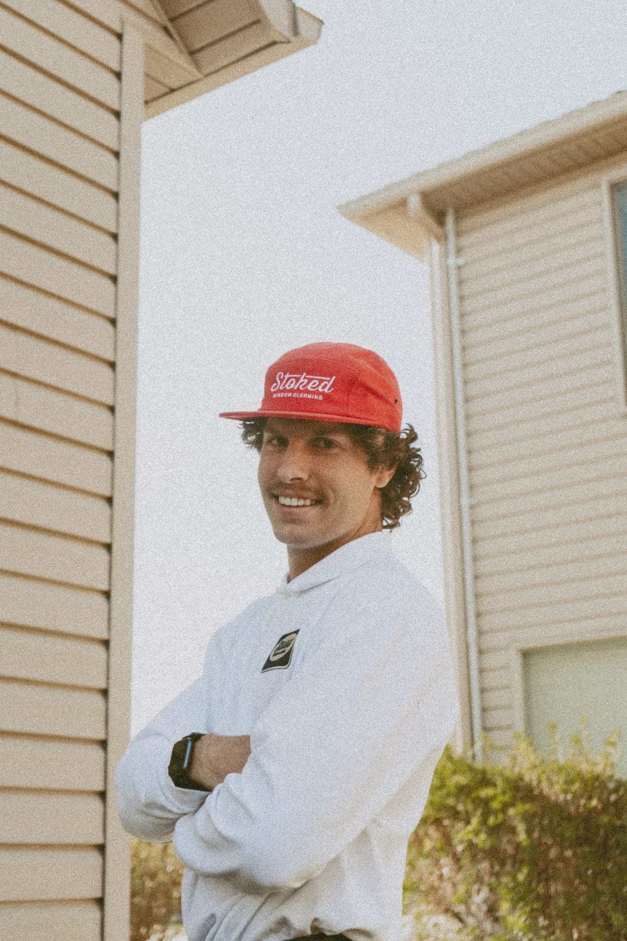 Stoked Window Cleaning team member smiling outside a home