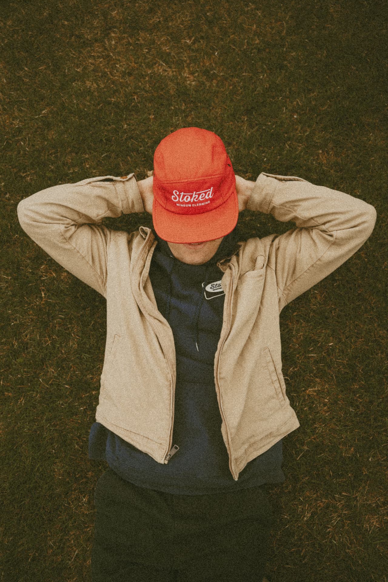 Stoked crew member resting on the lawn in branded Stoked gear